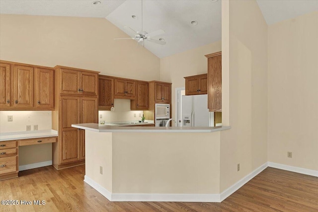 17 Windsong Pl, Whispering Pines, NC 28327 - kitchen featuring white appliances, high vaulted ceiling, ceiling fan, light wood finished floors, and built in study area