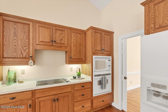 17 Windsong Pl, Whispering Pines, NC 28327 - kitchen with white appliances, brown cabinets, light countertops, and wood finished floors