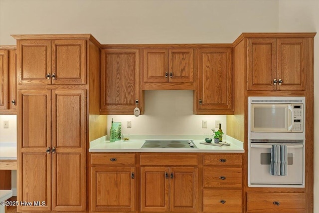 17 Windsong Pl, Whispering Pines, NC 28327 - kitchen with electric cooktop, brown cabinets, light countertops, and white microwave