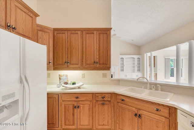 17 Windsong Pl, Whispering Pines, NC 28327 - kitchen featuring white appliances, vaulted ceiling, brown cabinets, a textured ceiling, and light countertops