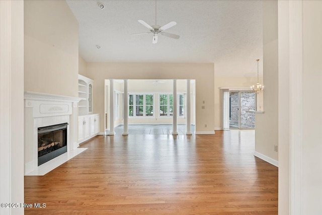 17 Windsong Pl, Whispering Pines, NC 28327 - unfurnished living room with ceiling fan, a fireplace with flush hearth, light wood-type flooring, a textured ceiling, and built in features
