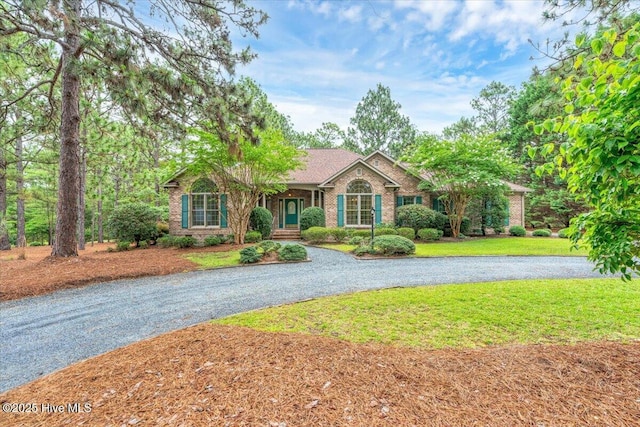 17 Windsong Pl, Whispering Pines, NC 28327 - single story home featuring curved driveway, brick siding, and a front yard