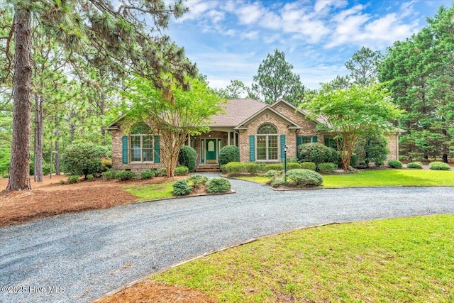 17 Windsong Pl, Whispering Pines, NC 28327 - ranch-style house with a front yard, driveway, and brick siding