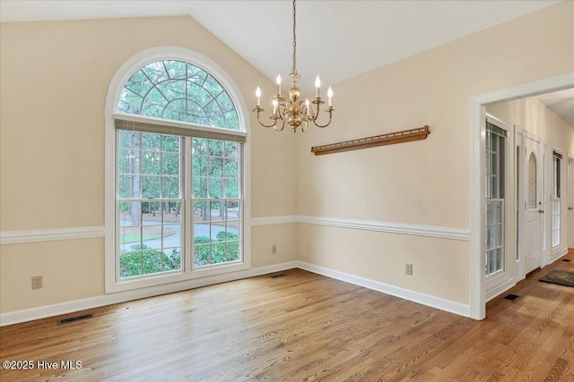 17 Windsong Pl, Whispering Pines, NC 28327 - empty room with plenty of natural light, a chandelier, lofted ceiling, and wood finished floors