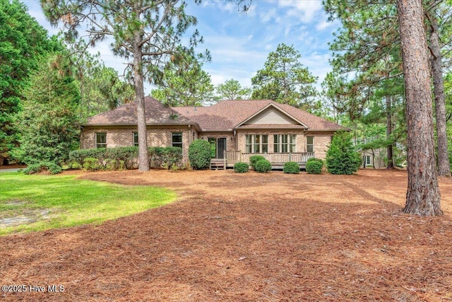 17 Windsong Pl, Whispering Pines, NC 28327 - ranch-style home featuring brick siding, a deck, and a shingled roof