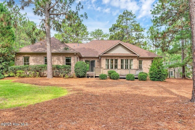 17 Windsong Pl, Whispering Pines, NC 28327 - ranch-style house with brick siding, a wooden deck, roof with shingles, and a front yard