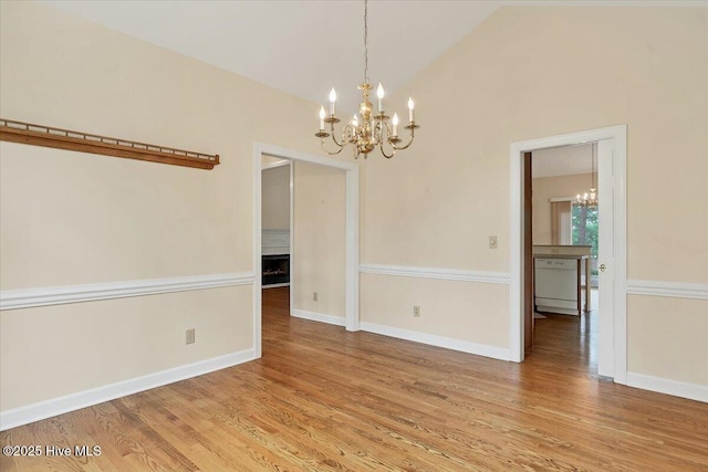 17 Windsong Pl, Whispering Pines, NC 28327 - empty room featuring a chandelier, light wood-style floors, a fireplace, and lofted ceiling