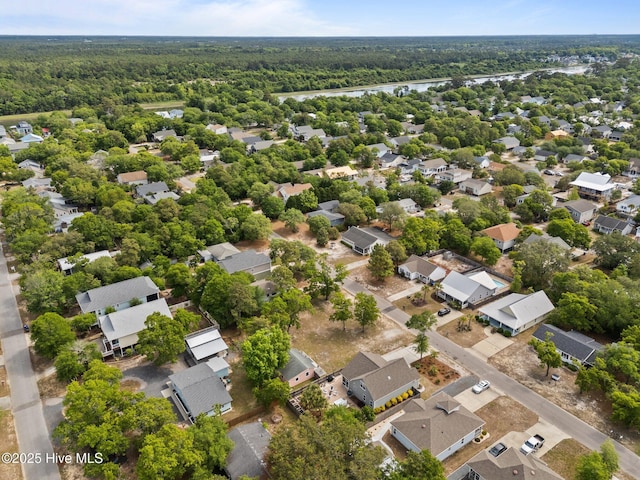 aerial view of residential area with a heavily wooded area and a nearby body of water