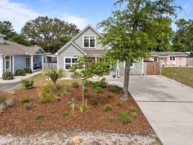 view of front facade featuring concrete driveway, fence, and board and batten siding