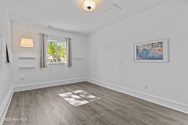 unfurnished room featuring wood finished floors and baseboards