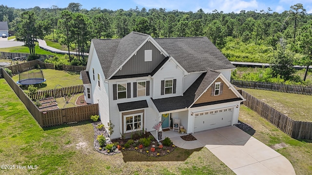 57 N Passerine Path, Hampstead, NC 28443 - view of front of property featuring roof with shingles, concrete driveway, board and batten siding, a forest view, and a fenced backyard