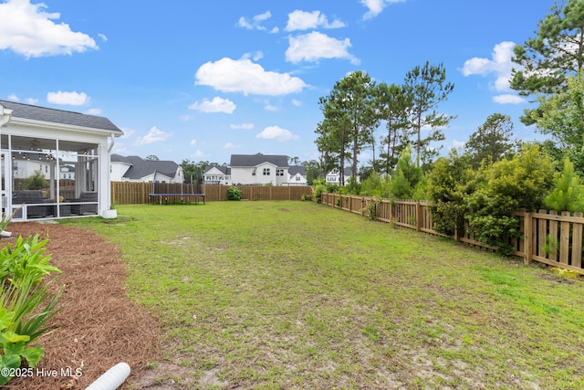 57 N Passerine Path, Hampstead, NC 28443 - fenced backyard with a trampoline, a sunroom, and a residential view