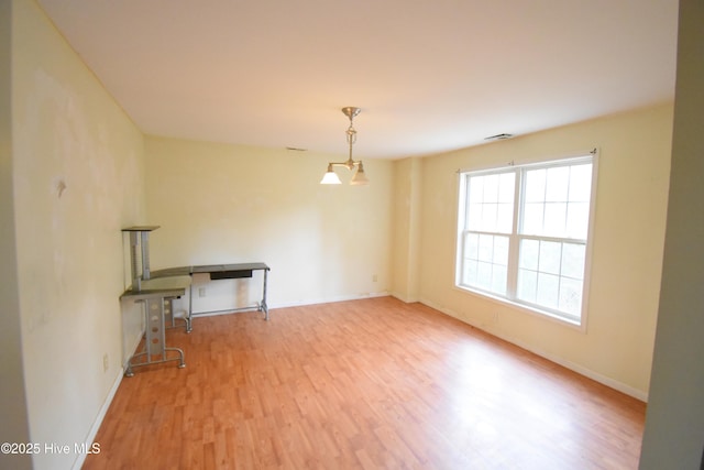 spare room with baseboards and wood finished floors