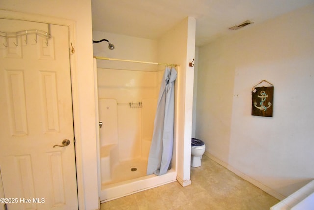 full bath featuring a shower stall, baseboards, toilet, and visible vents