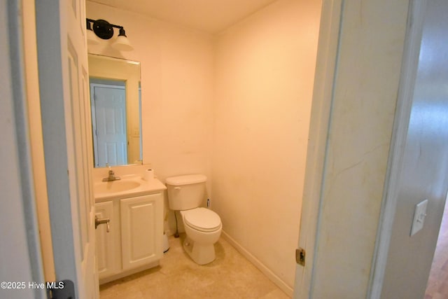 bathroom with baseboards, toilet, and vanity