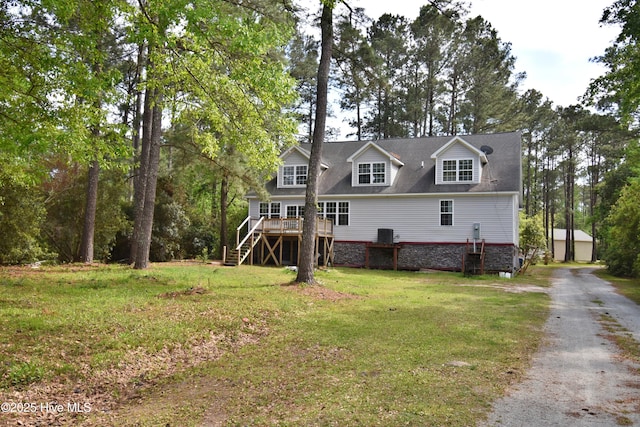 back of house featuring stairway, a lawn, an outbuilding, and a deck