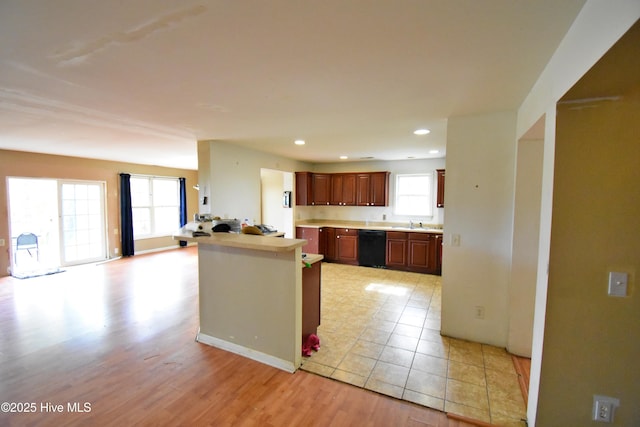 kitchen with a sink, recessed lighting, light wood-style floors, black dishwasher, and light countertops