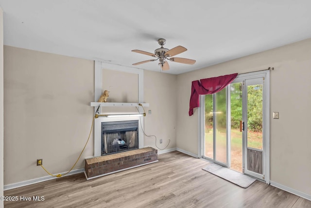 213 Spruce Ct, Jacksonville, NC 28546 - unfurnished living room with a brick fireplace, wood finished floors, baseboards, and a ceiling fan