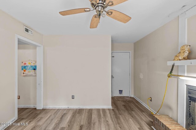 213 Spruce Ct, Jacksonville, NC 28546 - unfurnished living room with wood finished floors, a ceiling fan, baseboards, and a fireplace