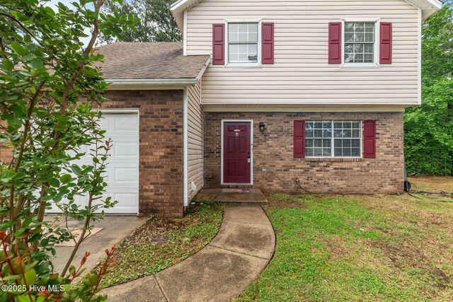 213 Spruce Ct, Jacksonville, NC 28546 - view of front of home featuring brick siding, an attached garage, a front lawn, and a shingled roof