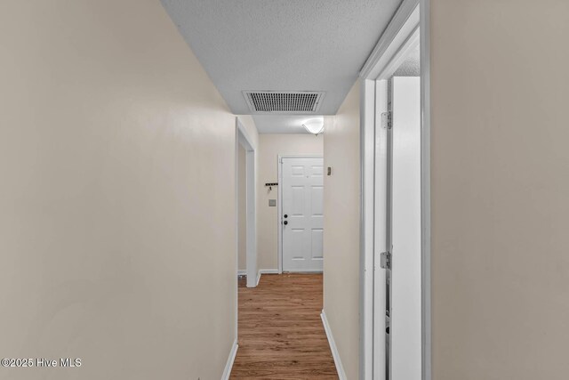 213 Spruce Ct, Jacksonville, NC 28546 - corridor with baseboards, wood finished floors, and a textured ceiling