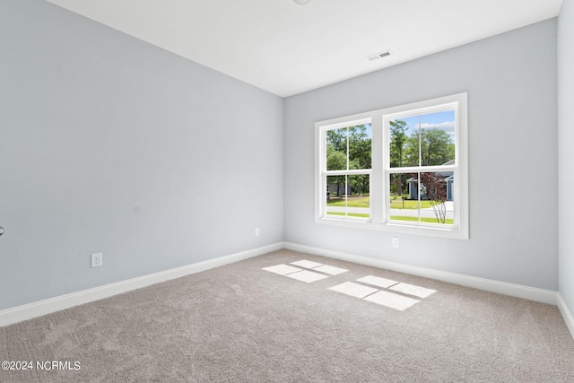carpeted spare room featuring baseboards and visible vents