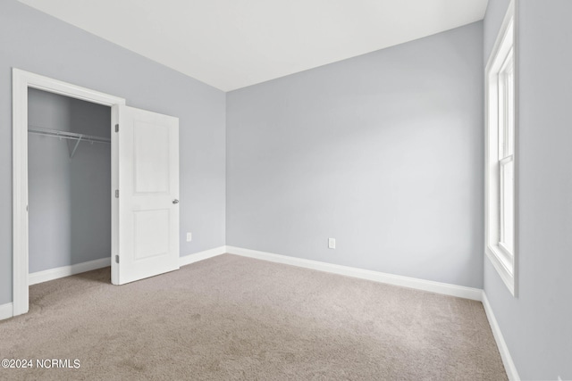 unfurnished bedroom featuring a closet, baseboards, and carpet floors