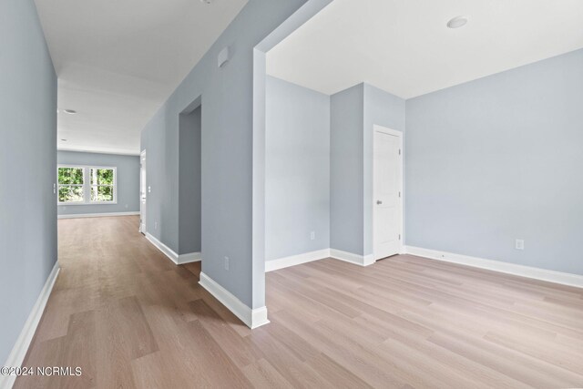 spare room featuring light wood finished floors and baseboards