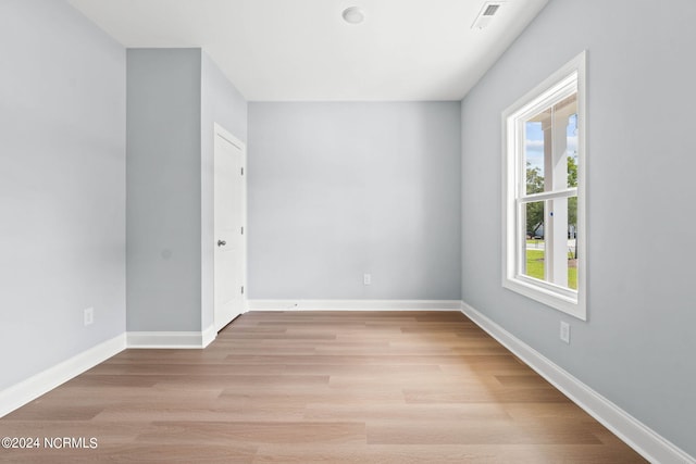 spare room with visible vents, light wood-style flooring, and baseboards