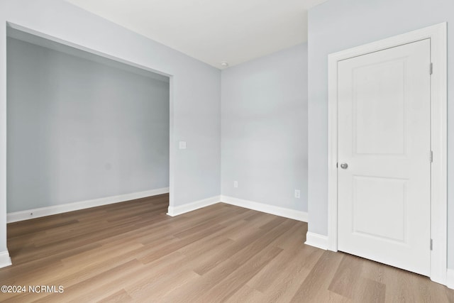 empty room with baseboards and wood finished floors