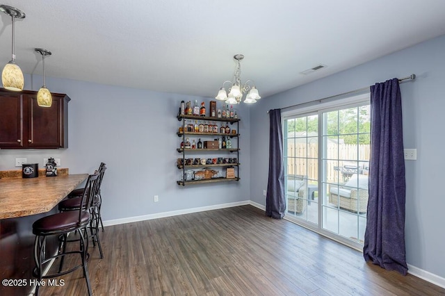 dining room featuring baseboards, a chandelier, dark wood-style floors, and visible vents