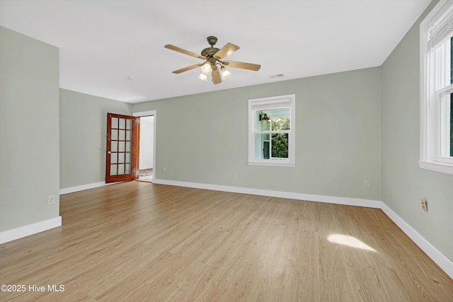 unfurnished room with baseboards, a ceiling fan, light wood-type flooring, and visible vents