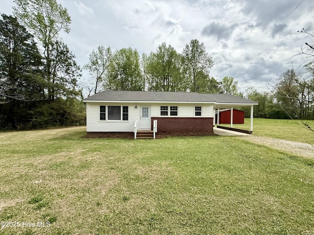 single story home featuring brick siding, a front yard, a carport, and driveway
