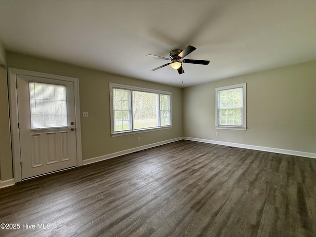 interior space with dark wood-style floors, ceiling fan, baseboards, and a healthy amount of sunlight