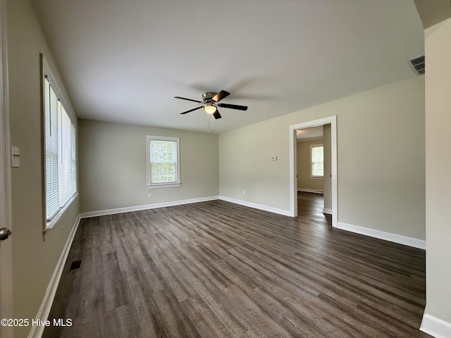 spare room with a wealth of natural light and dark wood-style floors