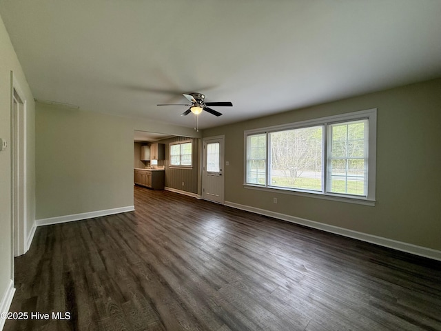 unfurnished living room with baseboards and a ceiling fan