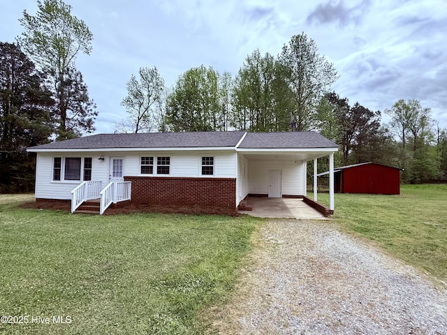 ranch-style home featuring brick siding, a front yard, a carport, and driveway