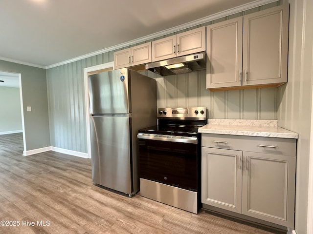 kitchen with ornamental molding, appliances with stainless steel finishes, under cabinet range hood, light wood finished floors, and gray cabinetry