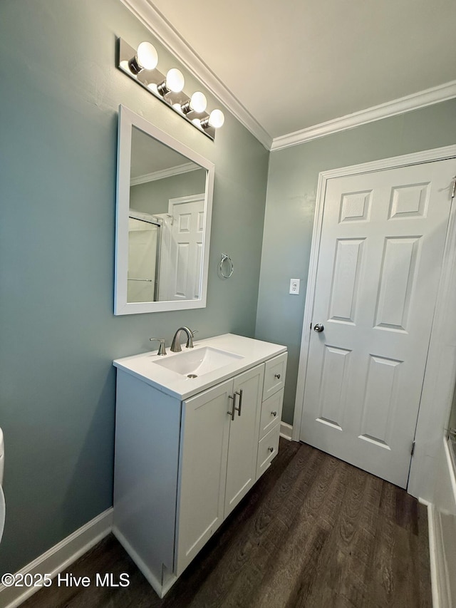 bathroom with vanity, crown molding, toilet, a shower, and wood finished floors