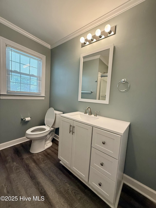 bathroom featuring ornamental molding, toilet, vanity, and wood finished floors