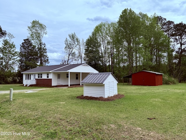 view of front of house with a front yard, a shed, and an outbuilding