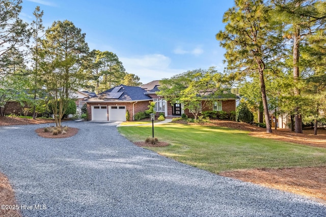120 Clay Cir W, End, NC 27376 - view of front of property featuring roof mounted solar panels, an attached garage, driveway, brick siding, and a front yard