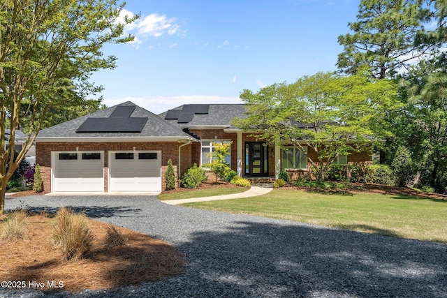 120 Clay Cir W, End, NC 27376 - prairie-style home featuring roof mounted solar panels, gravel driveway, an attached garage, brick siding, and a front yard