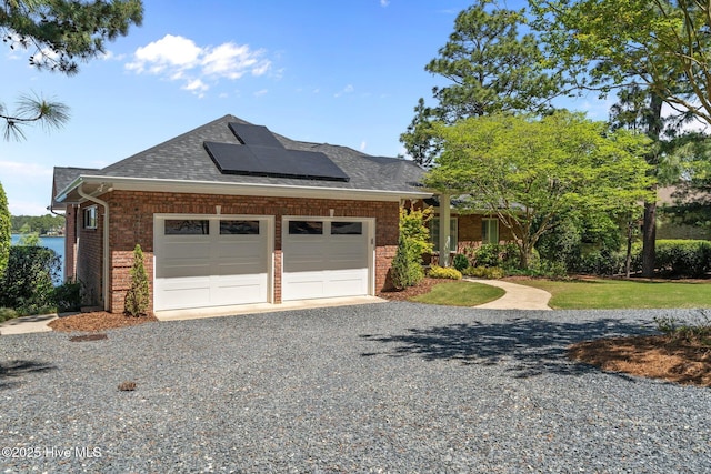 120 Clay Cir W, End, NC 27376 - exterior space featuring solar panels, brick siding, a garage, a shingled roof, and gravel driveway