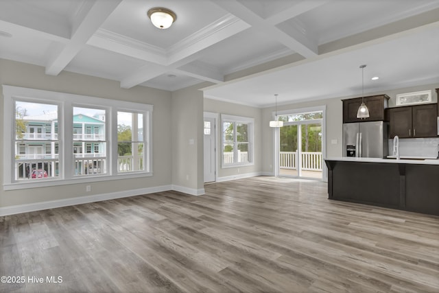 101 SE 68th St, Oak Island, NC 28465 - unfurnished living room featuring beam ceiling, baseboards, light wood finished floors, and coffered ceiling