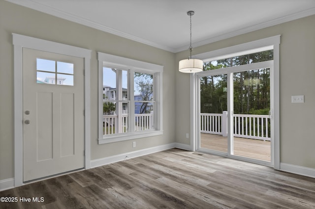 101 SE 68th St, Oak Island, NC 28465 - unfurnished dining area featuring baseboards, ornamental molding, and wood finished floors
