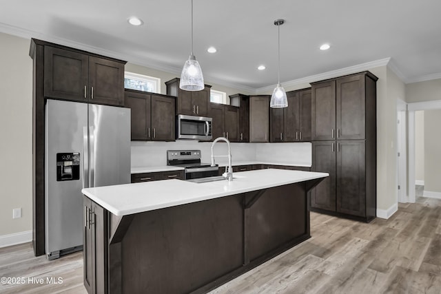101 SE 68th St, Oak Island, NC 28465 - kitchen with stainless steel appliances, light wood finished floors, a sink, and dark brown cabinetry