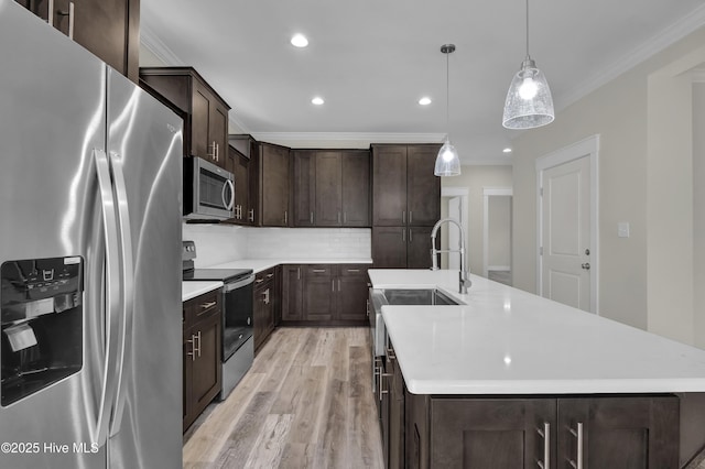 101 SE 68th St, Oak Island, NC 28465 - kitchen featuring light countertops, crown molding, dark brown cabinets, light wood finished floors, and stainless steel appliances