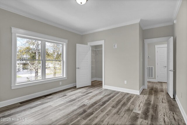 101 SE 68th St, Oak Island, NC 28465 - unfurnished bedroom featuring crown molding, visible vents, baseboards, and wood finished floors