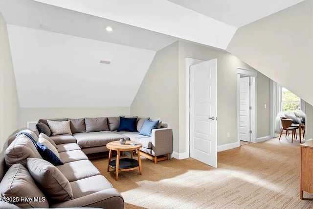 101 SE 68th St, Oak Island, NC 28465 - living area with light carpet, visible vents, baseboards, and vaulted ceiling